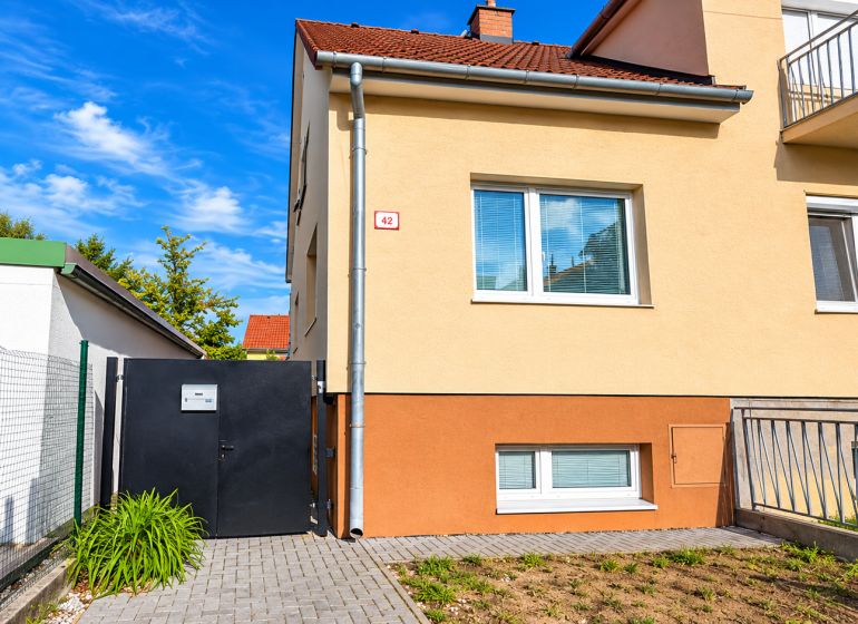 Rodinný dům na Kupeckého ulici v Piešťanech s oploceným dvorem a vstupní bránou.