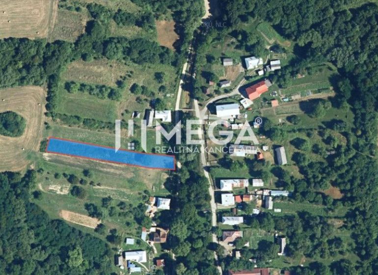 Letecký pohled na pozemky pro bydlení ve Vyšných Ladičkovcích obklopené políčky a lesem.