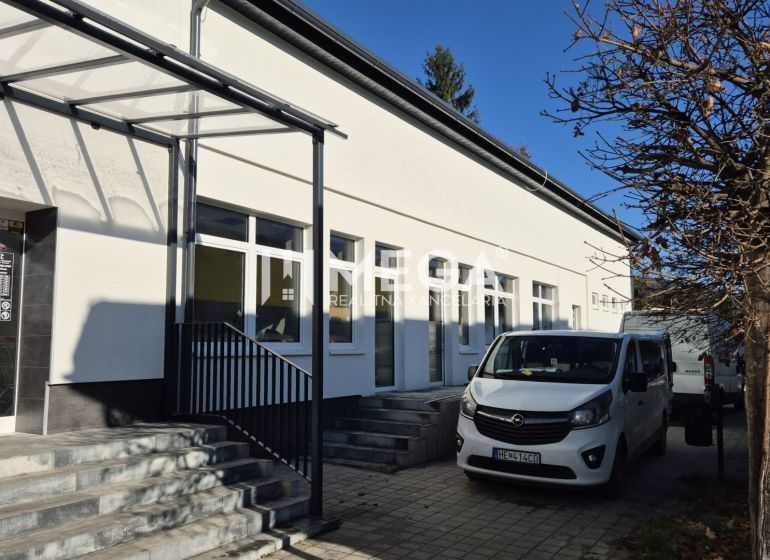 Budova s obchodními prostory na Tyršově ulici v Humenném, zaparkovaná auta, strom.