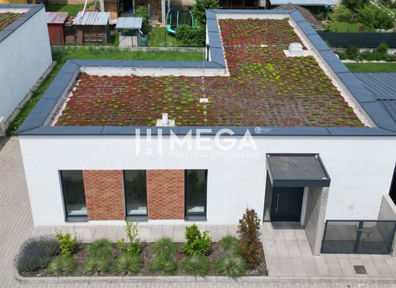 Rodinný dům na Kaštanové ulici v Humenném s extenzivní zelenou střechou a parkovacím místem.