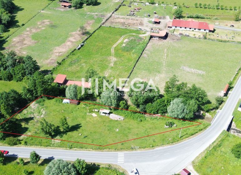 Pozemky - bydlení v Ptičom, obklopené zelení u hlavní silnice.