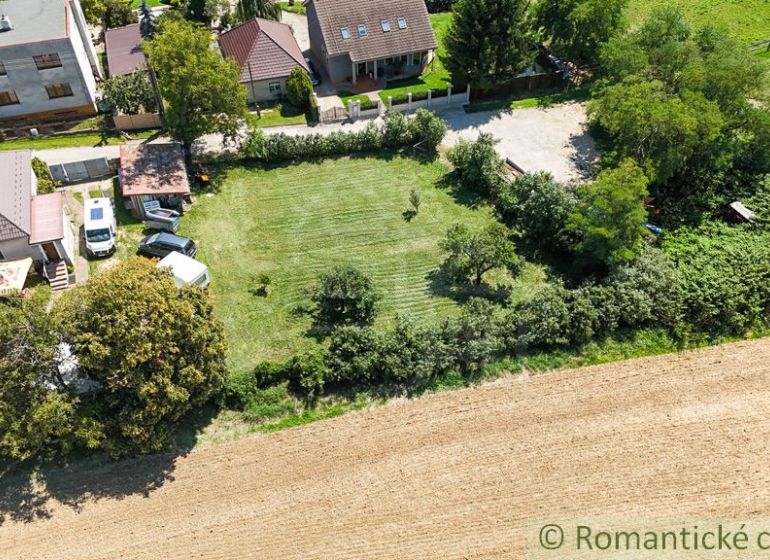 Domy se zahradami v Pastuchově obklopené polem a zelení.