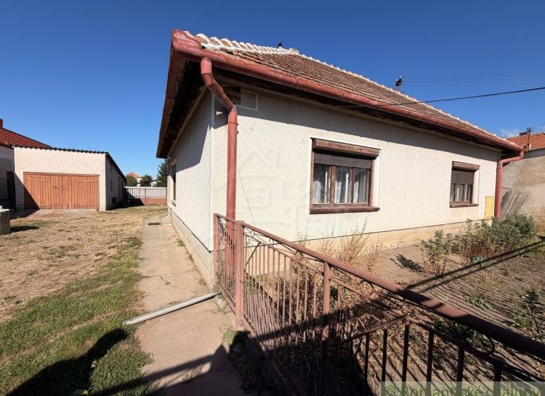 Rodinný dům v Hurbanově s velkou oplocenou zahradou, přilehlou garáží a travnatým pozemkem.