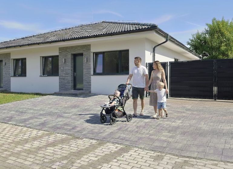 Rodinný dům v Hôrce nad Váhom s rodinou na dlážděné příjezdové cestě.