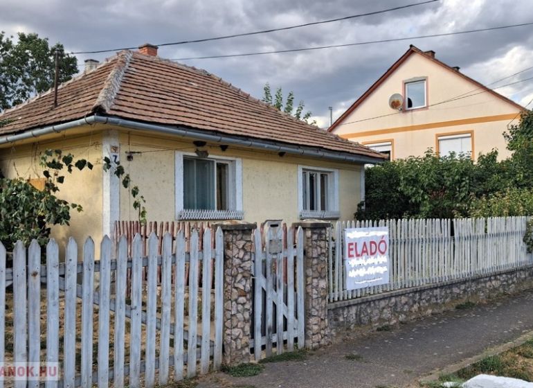 Rodinný dům v Tornyosnémeti s cihlovou střechou a barevným plotem.