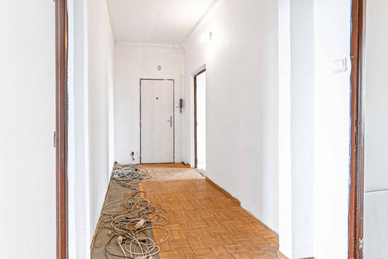 Renovácia na ulici Zimná: vchod v 3-izbovom byte s bielymi stenami a káblami.