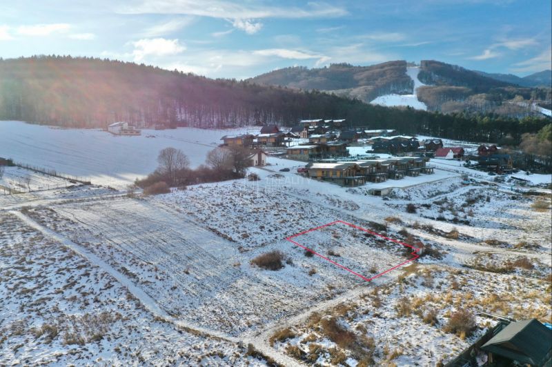 Zimní krajina v Rekreačních pozemcích ve Valči, na ulici Snowland, s horským pozadím.