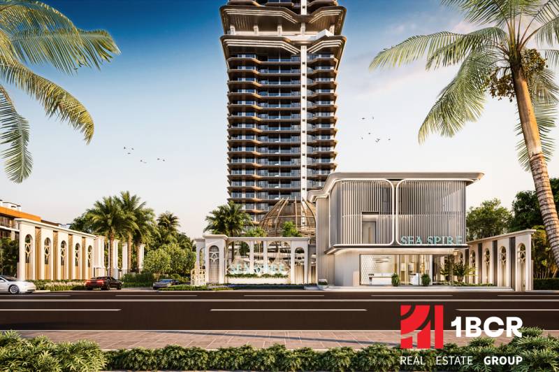 Výstavba bytů v Pattayi ukazuje výškovou budovu obklopenou palmami.