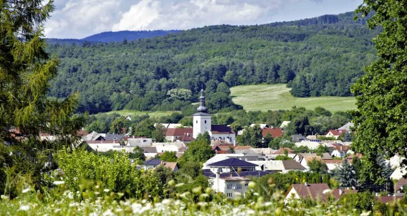 Malebná panoráma Lutile se zemědělskými a lesními pozemky a kostelem obklopeným zelenými lesy.