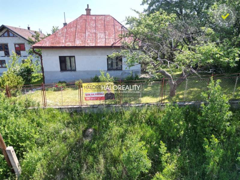 Rodinný dům ve Vrbovém, obklopený stromy a plotem, k prodeji.