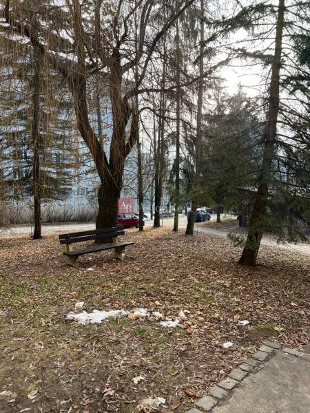 Park s lavičkou a stromy ve městě Banská Bystrica, ideální místo pro 2-pokojový byt.