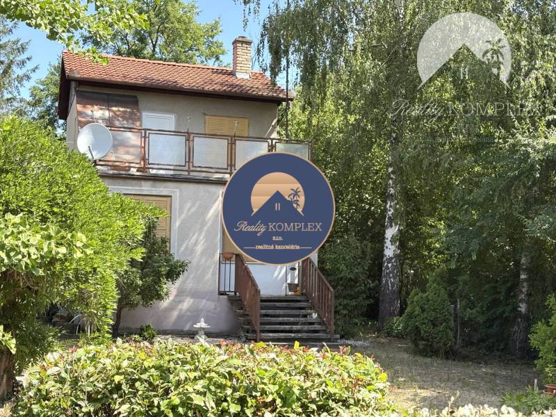 Chata v Radvaňi nad Dunajom, obklopená zelení s terasou a satelitem.