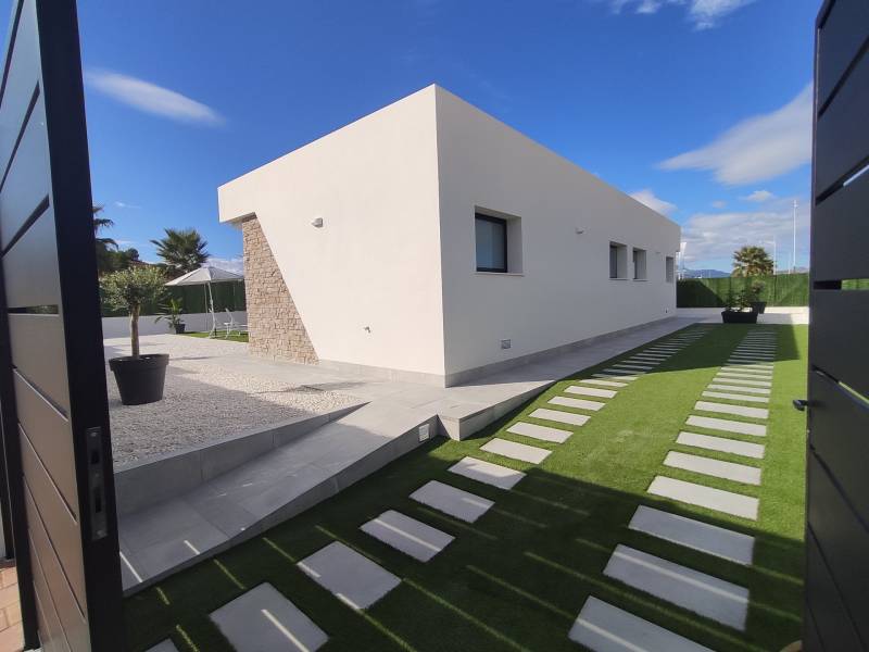 Vila v Calasparre se zahradní architekturou, kamennými detaily a upraveným trávníkem.