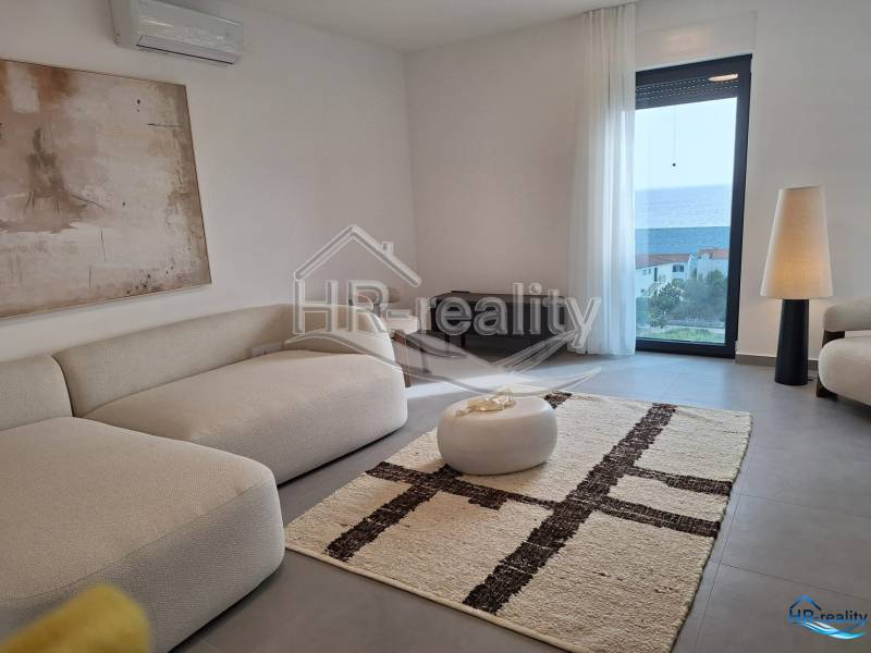Rekreační apartmán s pohodlným posezením, velkým oknem a výhledem na moře.