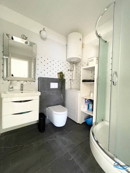 Koupelna v rekreačním apartmánu s WC, sprchou, umyvadlem a bojlerem.