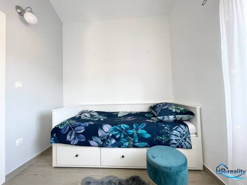 Rekreační apartmán s postelí a modrým vzorovaným povlečením.