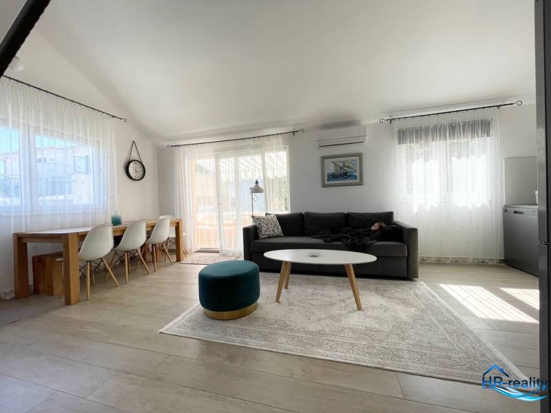 Prostorný obývací prostor rekreačního apartmánu s pohodlným posezením a jídelním stolem.