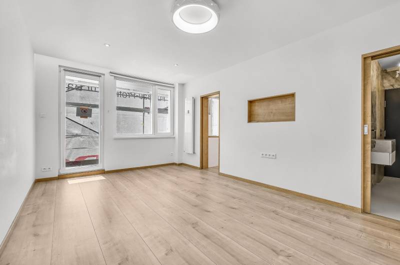 Světlý obývací pokoj s dřevěnou podlahou ve 4-pokojovém bytě.