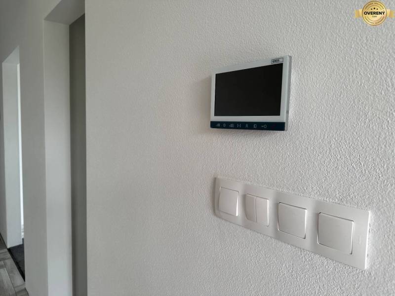 V rodinném domě jsou na stěně umístěny světelné vypínače a digitální displej.