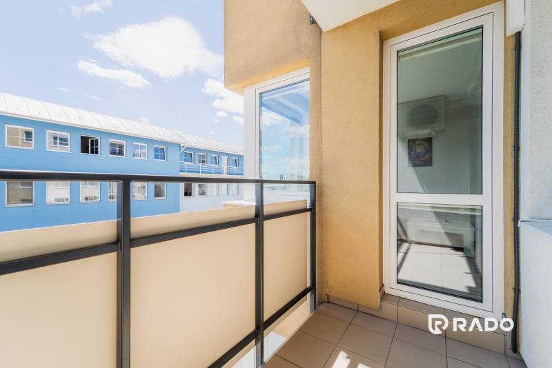 Balkon s výhledem na modrou budovu v 2pokojovém bytě v Trenčíně.