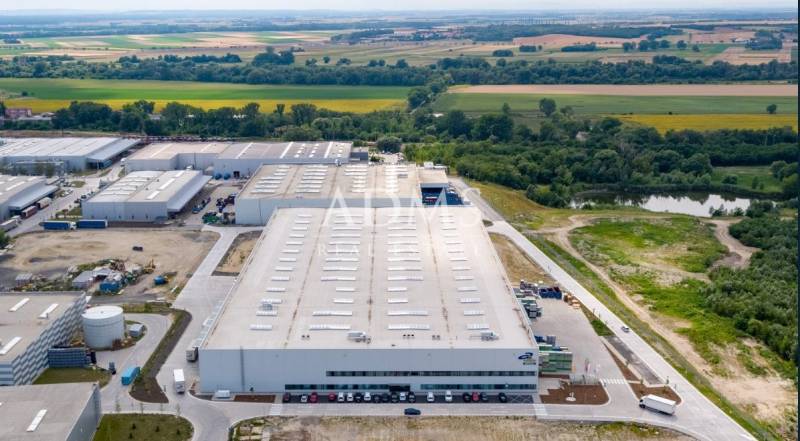 Logistické sklady a haly v Bratislavě - Devíně obklopené zelení a cestami.