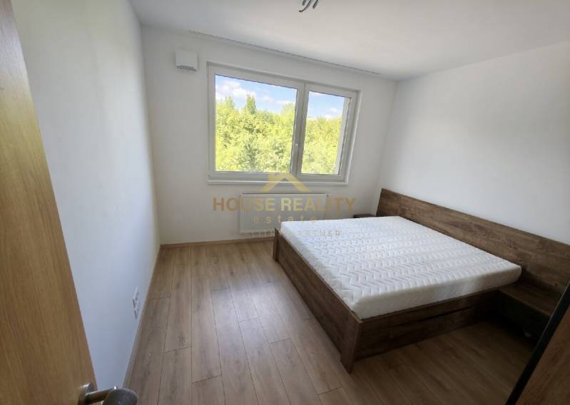 Ložnice ve 3pokojovém bytě s postelí a výhledem do zeleně.