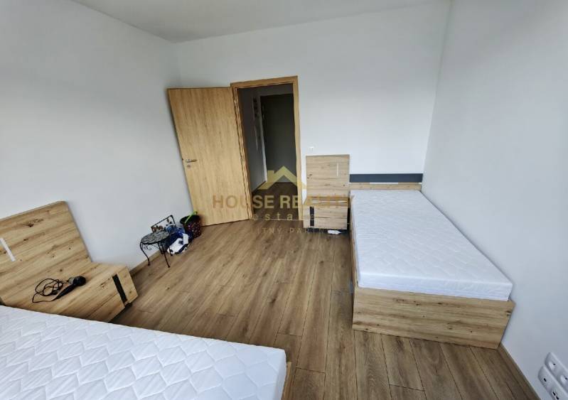 Ložnice se dvěma jednolůžkovými postelemi a dřevěnou podlahou, 3pokojový byt.