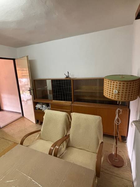 Retro místnost: stará křesla, stolní lampa, knihovna; ideální pro rekreační pozemky.