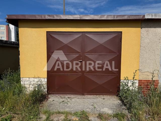Hnědá garáž na Zahradní ulici ve Svitu s rostlinami okolo.