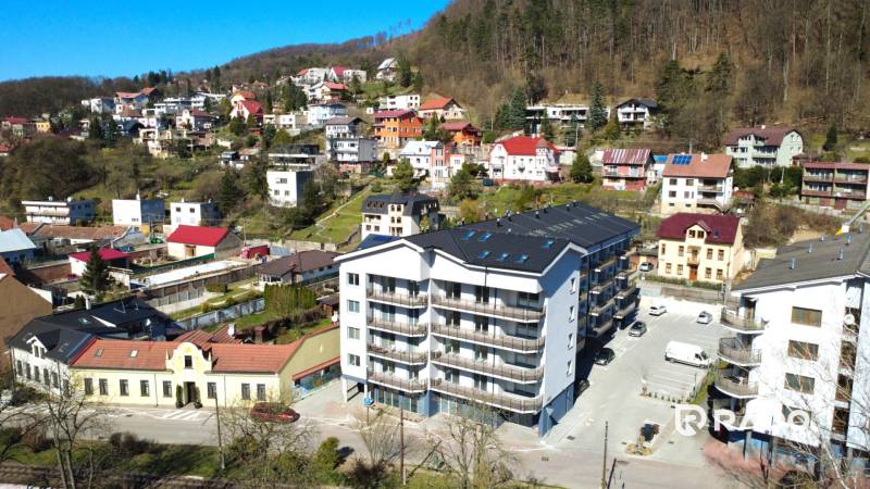 Obrázek zachycuje okolní domy a nový apartmánový komplex na ulici Nádražní.