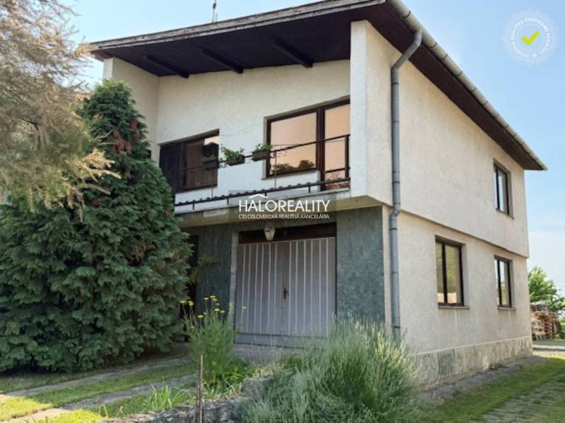 Rodinný dům v Borši s dvěma podlažími, zahradou a jehličnatými stromy.
