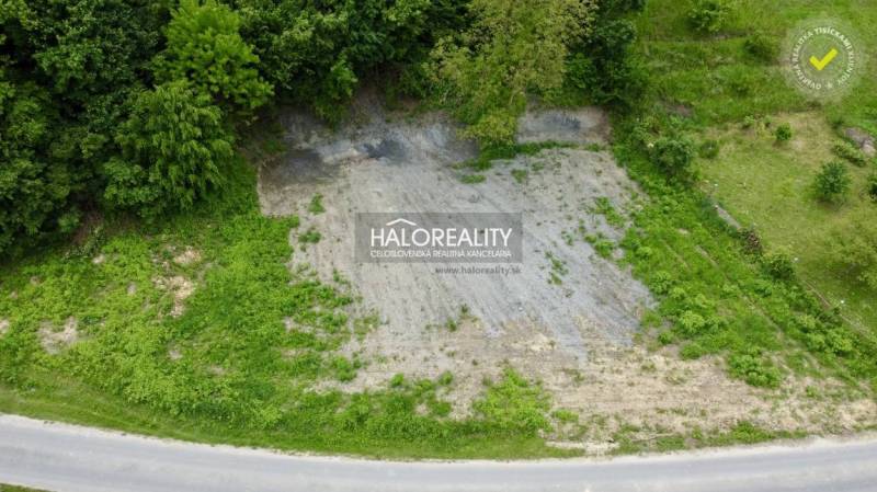 Pozemek určený k bydlení v Selcích, obklopený zelení u cesty.