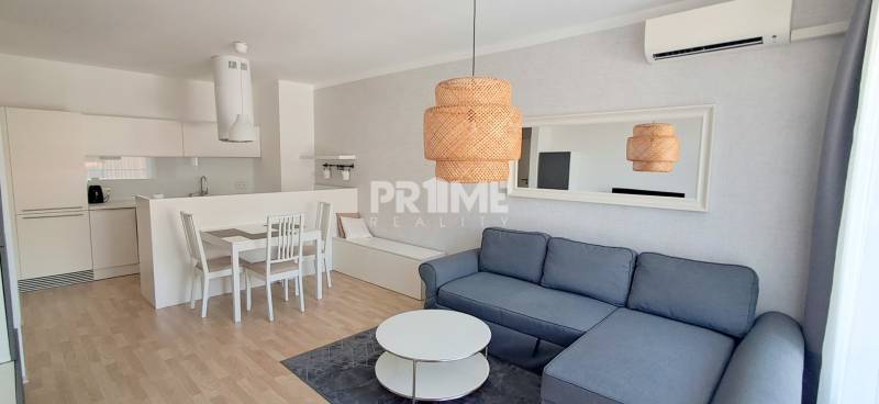 Pohodlný obývací pokoj s kuchyní v 2pokojovém bytě s elegantním nábytkem a osvětlením.