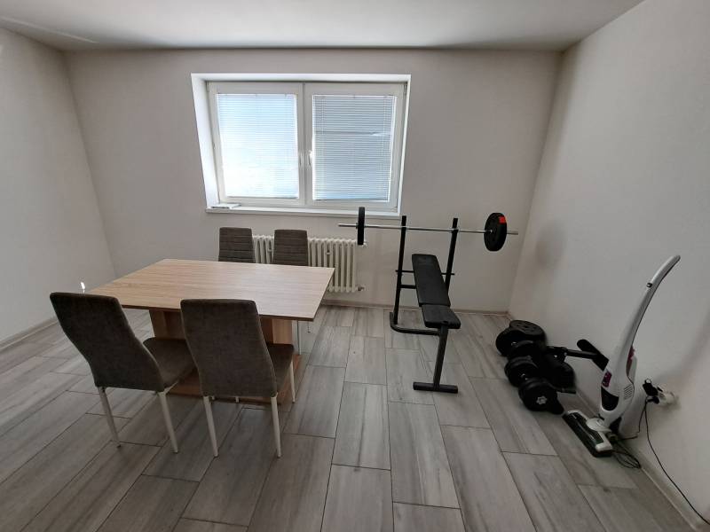 Jídelna v rodinném domě s fitness prvky a stolem se židlemi.