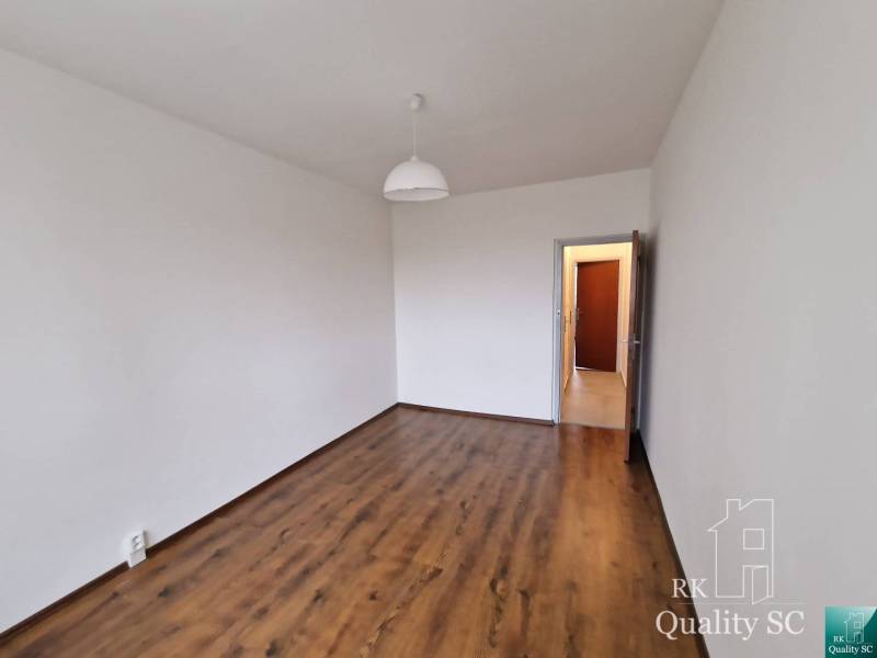 Pokoj se světlou dřevěnou podlahou v dekoru ve 4pokojovém bytě, bílé stěny.