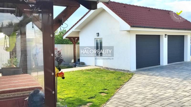 Exteriér rodinného domu v Kalinově s trávníkem, terasou a dvojgaráží.