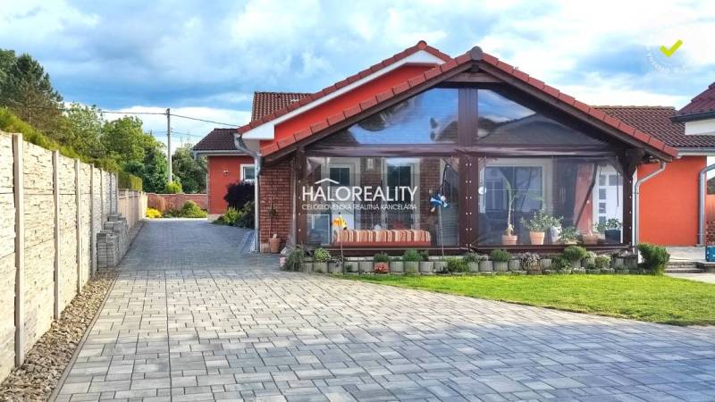 Rodinný dům v Kalinově s dlážděnou příjezdovou cestou a prosklenou verandou.