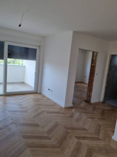 Interiér 4-pokojového bytu s dřevěnou podlahou a velkými okny.