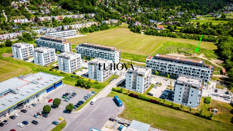 Letecký pohled na bytovky a parkoviště v Púchově na Dlhých lúkach s výhledem na 2-pokojový byt.