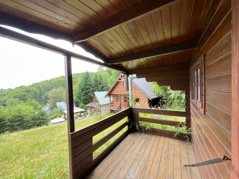 Dřevěná veranda rodinného domu ve Štefultově s výhledem na zalesněné okolí.