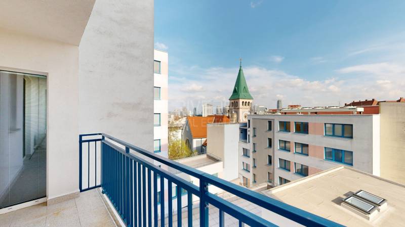 Pohled z balkonu na kostelní věž a panoráma Bratislavy ve 3-pokojovém bytě.