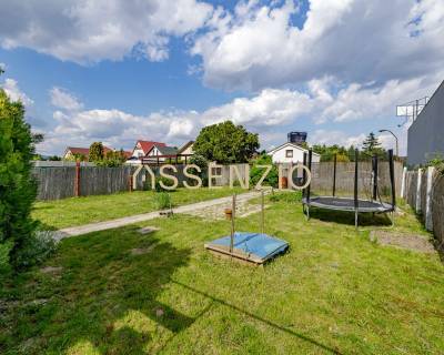 Zahrada rodinného domu na Mokráň záhone v Bratislavě-Ružinově s trávníkem a trampolínou.