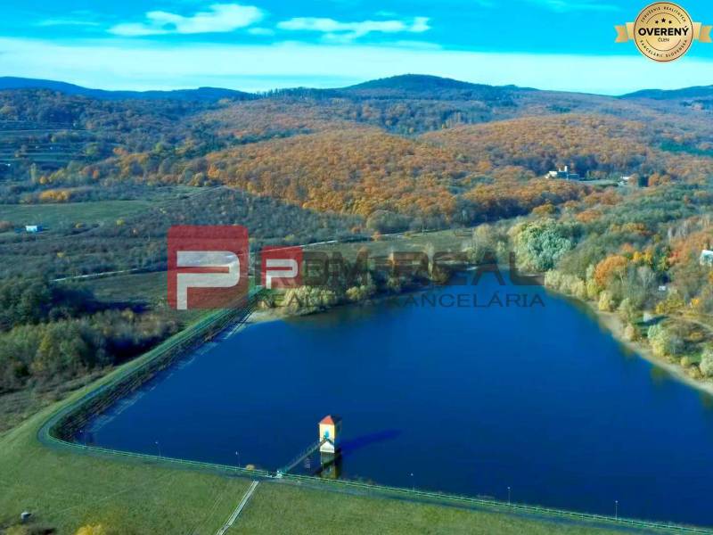 Jezero obklopené podzimní krajinou v oblasti Pezinku, vhodné pro Pozemky - bydlení.