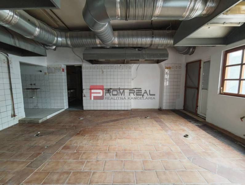 Obchodní prostory s dlaždicovou podlahou a ventilací.
