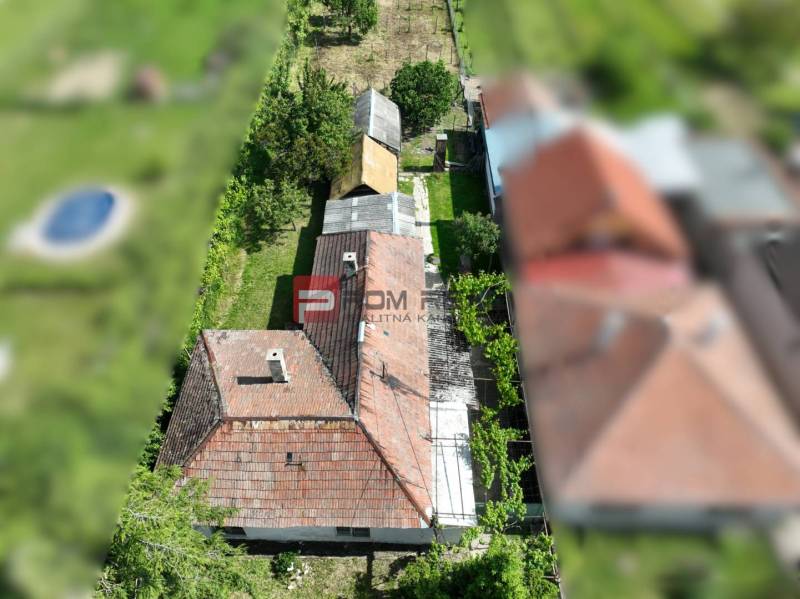 Letecký pohled na dům obklopený zelení v Dolních Orešanech, centrum, Pozemky - bydlení.
