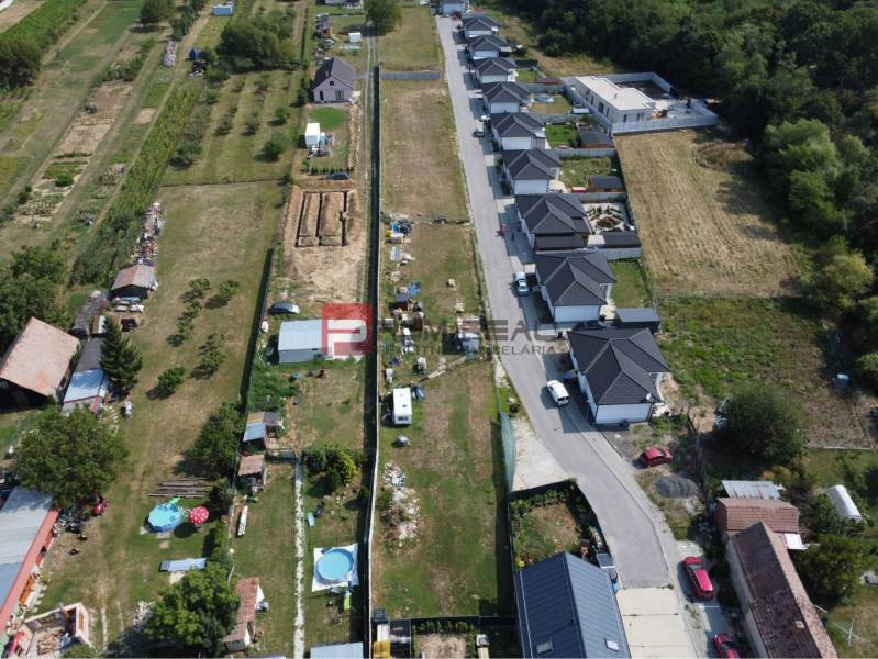 Letecký pohled na pozemky pro bydlení ve Štefanové, sousedící s řadovou výstavbou domů.