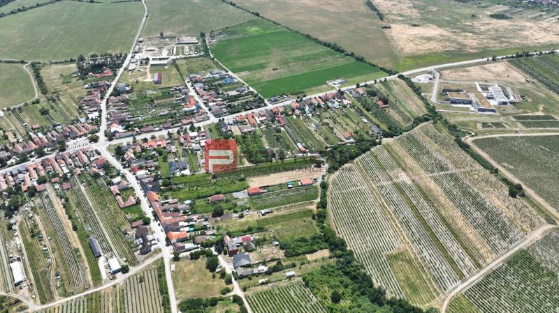 Letecký pohled na Dubovou, uspořádané ulice a okolní pole, pozemky - bydlení.