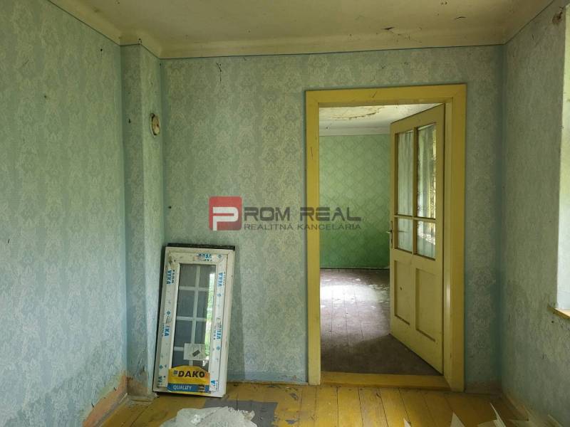 Interiér s tapetami a starou podlahou, Pozemky - bydlení. Dodává venkovskou atmosféru.