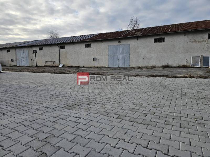 Exteriér průmyslové budovy na ulici Partizánská, sklady a haly na dlažbě.
