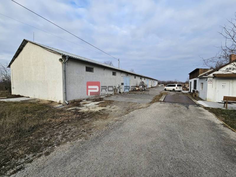 Na ulici Partizánská jsou viditelné sklady a haly vedle cesty.